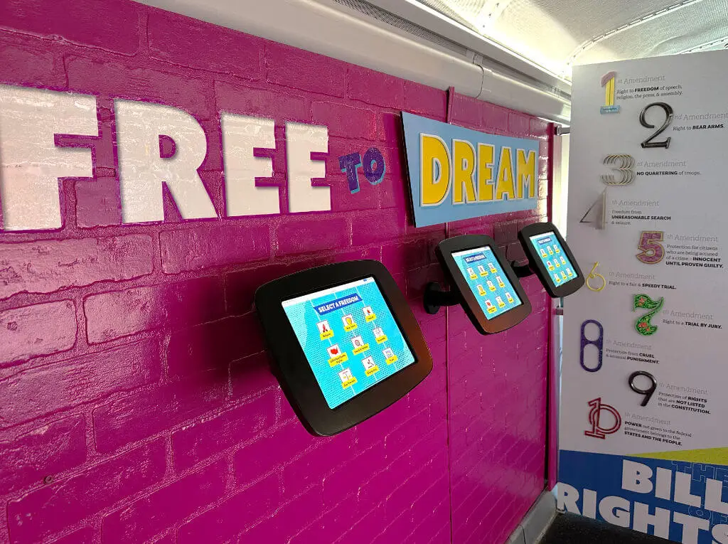 interior of united we pledge liberty bus with wall describing free to dream and ipads about bill of rights